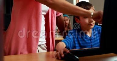 老师在计算机课上帮助小男孩
